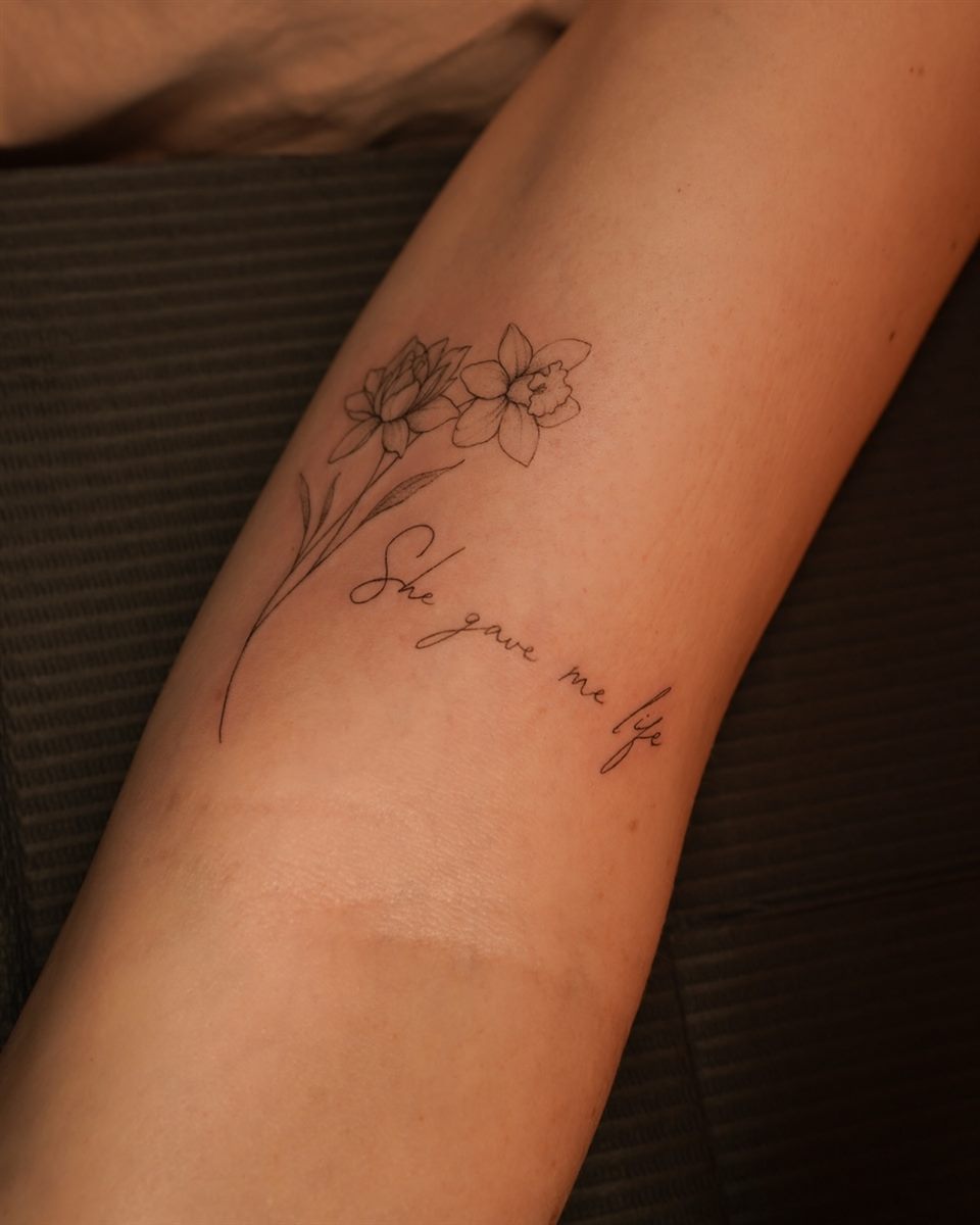 floral script arm tattoo idea for women